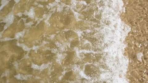 Top full HD slow motion view on shallow blue sea water, waves and sandy beach Stock Footage 249970186