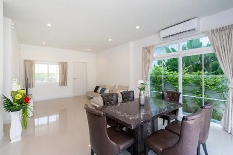 Top granite dining table with dining chairs in spacious room in villa, house  Stock Photos