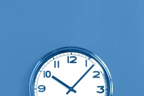 Top half of big wall clock on blue background Stock Photos