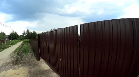 Top high angle view of young girl slowly opening iron gates, Surveillance Camera Stock-Footage 64918649