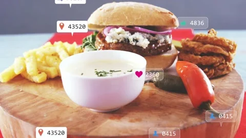 Top-left badges floating in, plated burger meal accumulating engagement icons, Stock Footage 332522832