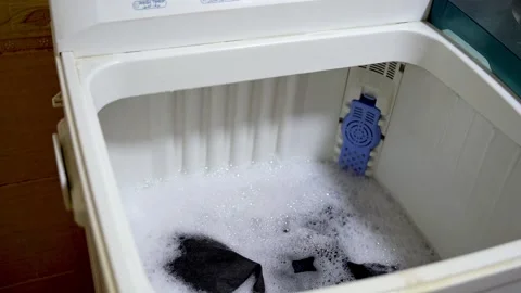 Top-Loading Washing Machine Vigorously Churning Clothes in Soapy Water Stock Footage 322717764
