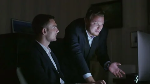 Top manager instructs an employee working at night at the computer Stock Footage 54935229