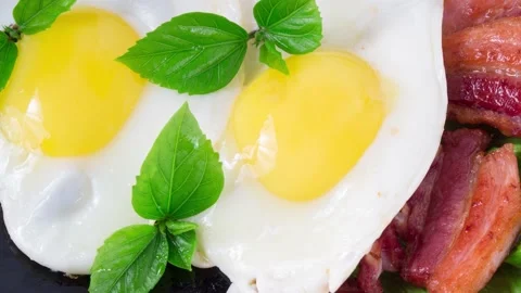 Top motion close-up on a plate with fried eggs and fried bacon Stock Footage 132745261