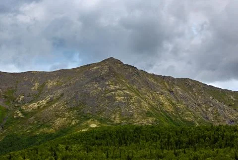 Top mountain Khibiny in the form of a background of the cloudy sky. Stock Photos
