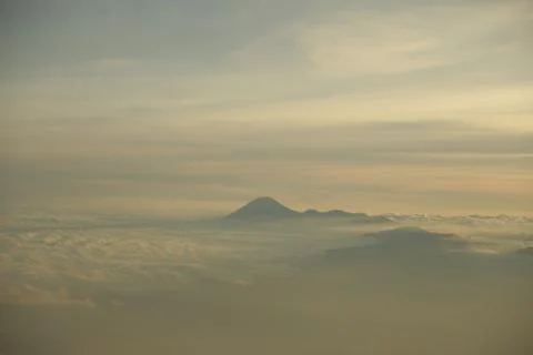 Top of the mountain reaching above the clouds at sunrise Stockfoto's