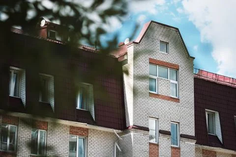 The top of a multi-storey building, a view of the roof and the sky. Brick house Stock Photos