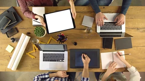Top overhead view people group sharing tablet and shaking hands on a design Video stock 75312439
