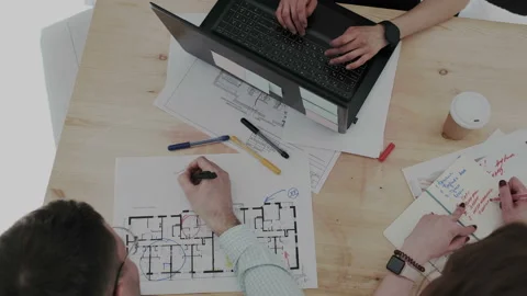 Top overhead view. Three creative design professionals intensely working with Stock Footage 106202020