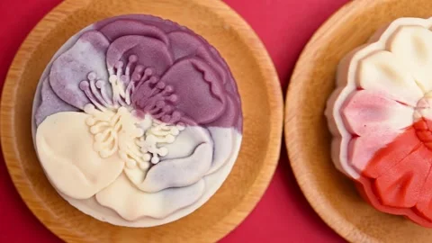 Top pan trendy different flower shapes mooncakes on red background Stock Footage 247831206