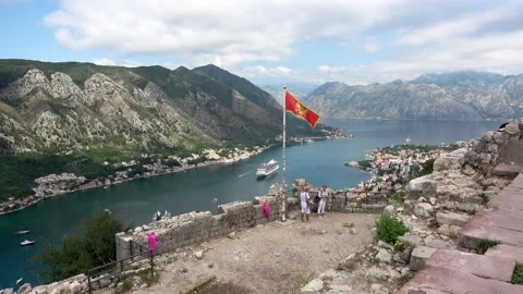 Top panorama view with waving flag and cruise liner ship in port of Kotor city Stock Footage 92741990