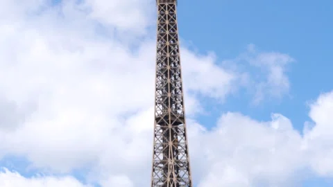 Top part of the Eiffel Tower against sky with fluffy clouds, Paris, France Stock Footage 260700480