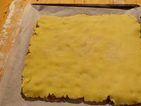 Top pastry layer aligned smoothly over filling on rustic baking surface 스톡 사진