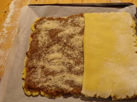 Top pastry layer folded over apple filling on rustic baking surface Stockfoto's