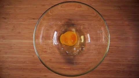 Top plan ingredients on a wooden table. Raw eggs were broken in a glass bowl Stock Footage 139799069