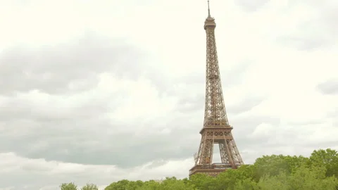 Top portion of Eiffel tower standing tall with trees in the base in a Stock Footage 280093751