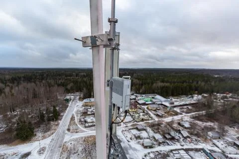 Top of red telecommunication tower with vertical panel antenna and remote radio Stock Photos