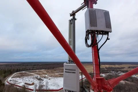 Top of red telecommunication tower with vertical panel antenna and remote radio Stock Photos