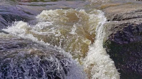 Top section of small waterfall in slow motion showing water being sucked dow Stock Footage 142400486