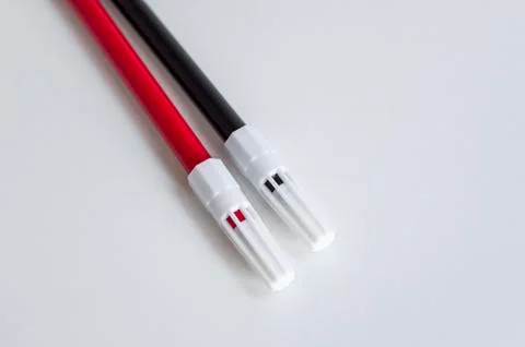 Top shoot of side positioned red and black magic marker pen on white surface Foto stock