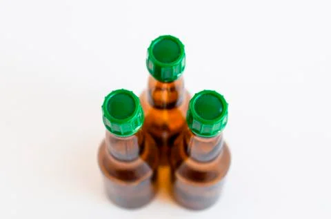 Top shoot of three triangled positioned small alcohol bottles brown colored Stock Photos