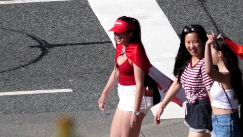 Top shot of camera chasing young girls walking and waving Canada flag Stock Footage 77414467