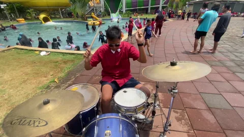 Top shot of a drummer playing drum at outdoor local swimming pool Stock Footage 255695068