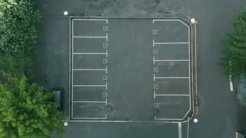 Top shot empty parking lot. dry asphalt sunny day. white line markings Stock Footage 154965104