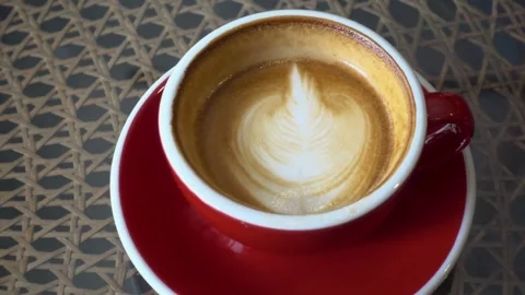 Top shot of a Fresh coffee served in a cup with latte art on the table. 動画素材 334648790