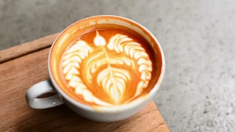 Top shot of a Fresh coffee served in a cup with latte art on the table. Stock-Footage 334648809