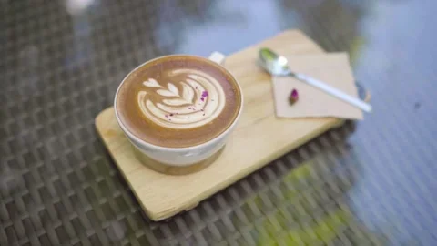 Top shot of a Fresh coffee served in a cup with latte art on the table. Stock Footage 334648831