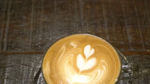 Top shot of a Fresh coffee served in a cup with latte art on the table. 動画素材 334650934