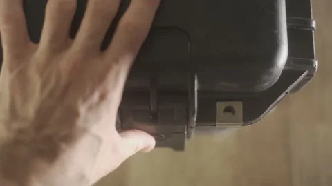 Top shot - hand opens latch of protective hard case used for professional gear Stock Footage 131899444