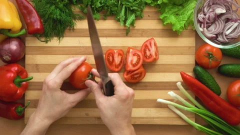 Top shot of man chef cutting tomatoes on chopping wooden board Stock Footage 87806291