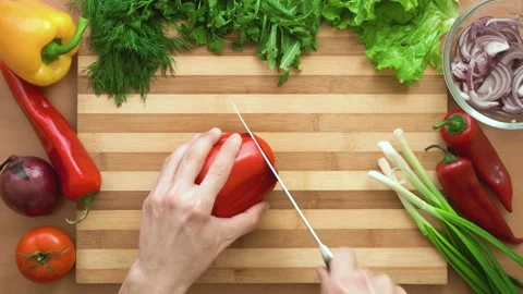 Top shot of man chef cutting bell pepper on chopping wooden board Stock Footage 87807346