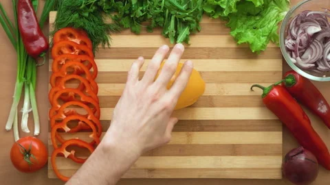 Top shot of man chef cutting bell pepper on chopping wooden board Stock Footage 87807600