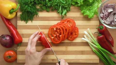 Top shot of man chef cutting bell pepper on chopping wooden board Stock Footage 87903515