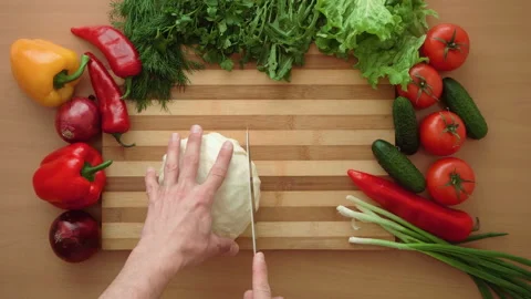Top shot of man chef cutting cabbage on chopping wooden board Stock Footage 87990169