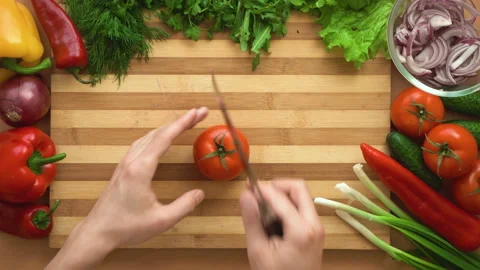 Top shot of man chef cutting tomatoes on chopping wooden board Stock Footage 87993839