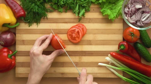 Top shot of man chef cutting tomatoes on chopping wooden board Stock Footage 87996158