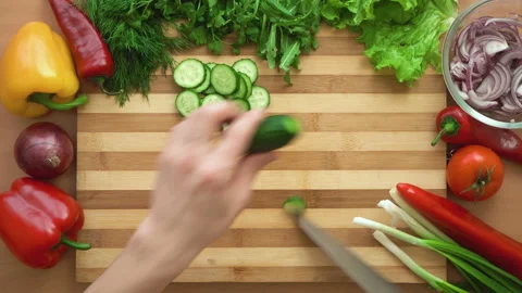 Top shot of man chef cutting cucumber on chopping wooden board Stock Footage 87997882