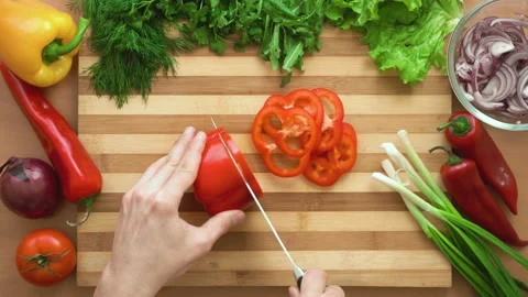 Top shot of man chef cutting bell pepper on chopping wooden board Stock Footage 88001045