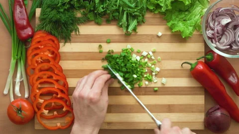 Top shot of man chef cutting greens on chopping wooden board Stock Footage 88002463