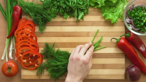 Top shot of man chef cutting greens on chopping wooden board Stock Footage 88003507