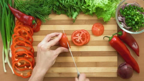 Top shot of man chef cutting tomatoes on chopping wooden board Stock Footage 88005700