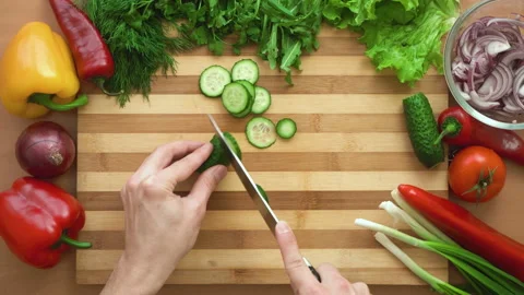 Top shot of man chef cutting cucumber on chopping wooden board Stock Footage 88174587
