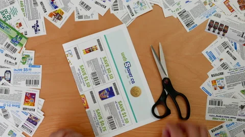 Top shot of man cutting coupon with various coupons background Stock Footage 65828012