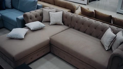 Top shot of a modern brown sofa with six white pillows arranged in a messy style Stock Footage 235058546