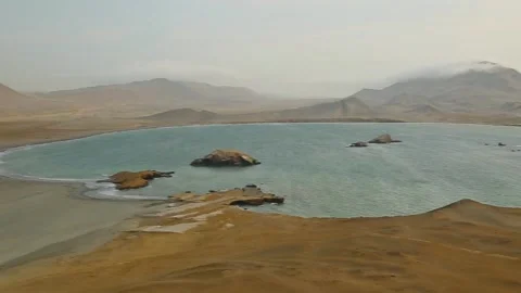 Top shot ocean harbor between mountain and sandy desert, milky sky, golden Peru Stock Footage 202526774