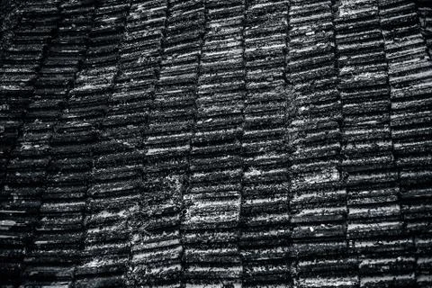Top shot of the old-styled rectangular-shaped rooftop tiles fixed on a roof o Stock Photos